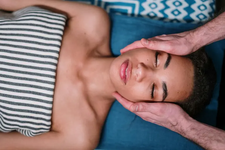 Mujer recibiendo un masaje facial en clínica estética