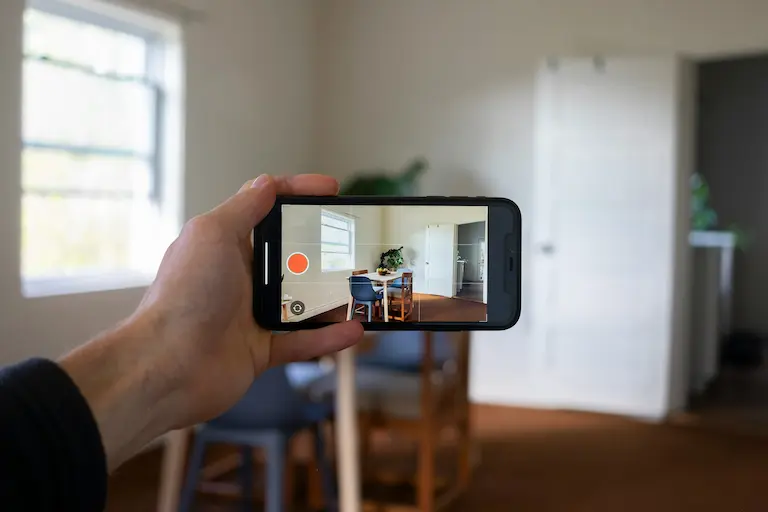 Mano sosteniendo un móvil mostrando un tour virtual 360º de un local